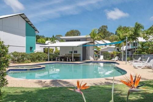 a swimming pool in front of a house at Tranquil Noosa retreat minutes from the river 40IP in Noosaville