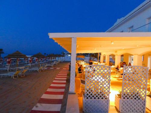 un bar sulla spiaggia con un tappeto a righe rosso e bianco di Albergo Lido Diomedee a Rodi Garganico