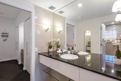 a bathroom with two sinks and a large mirror at Poolside luxury on Hastings St 212 in Noosa Heads