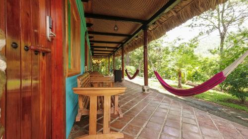 a porch of a house with a hammock on it at El Retiro Lanquin in Lanquín