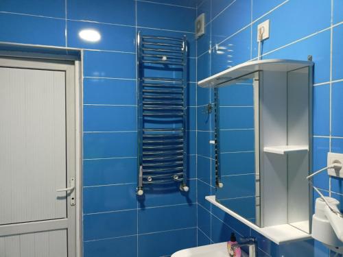 a blue tiled bathroom with a shower and a toilet at Hotel Lilo near Airport in Tbilisi City