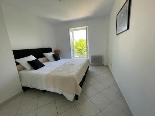 une chambre avec un grand lit et une fenêtre dans l'établissement maison lumineuse, à Villemoustaussou