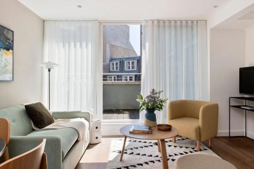 a living room with a couch and a window at Cove St Martin's in London