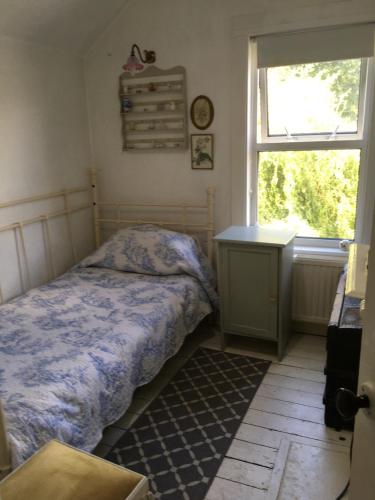 a bedroom with a bed and a desk and a window at Arts&BichonsB&B in Oxford