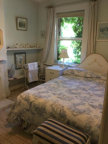 Un dormitorio con una cama grande y una ventana en Arts&BichonsB&B, en Oxford