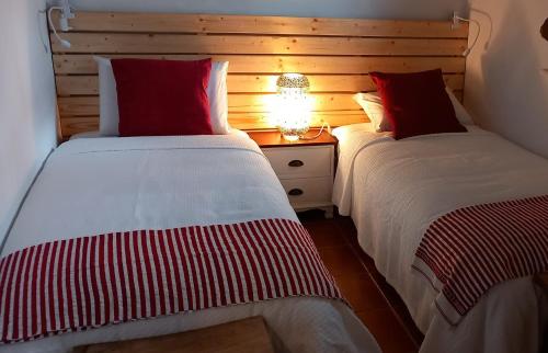 dwa łóżka siedzące obok siebie w sypialni w obiekcie Casa das Rosas w mieście Crato