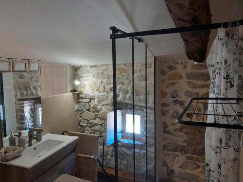 un bagno con lavandino e doccia in vetro di LA TERRASSE AUX HIRONDELLES maison 80m2 2 chambres 2 salles de bains a Lagorce