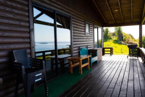 a porch of a log cabin with a table and chairs at Cabañas Mirador Lago Ranco in Lago Ranco