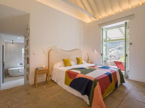 a bedroom with a bed and a bathroom with a tub at Agroturismo Suites Hacienda los Olivos in Santa Brígida