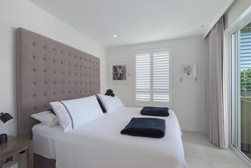 Un dormitorio con una gran cama blanca y una ventana en Luxury in the Heart of Hastings street 628 en Noosa Heads