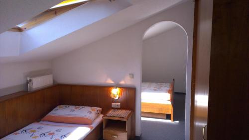 ein kleines Schlafzimmer mit 2 Betten und einem Spiegel in der Unterkunft Pension Miklautz in Sankt Kanzian am Klopeiner See