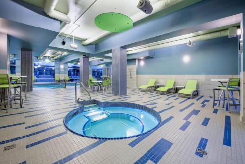 a hot tub in a room with tables and chairs at Holiday Inn Express & Suites Kelowna - East by IHG in Kelowna