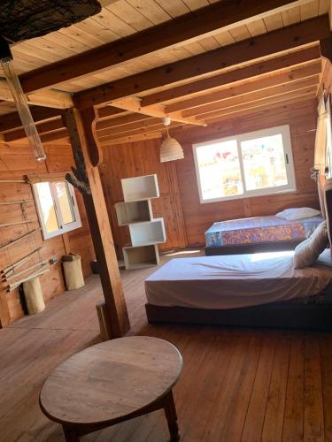 1 dormitorio con 1 cama y 1 mesa en una cabaña en Saidïa marina, en Saidia 