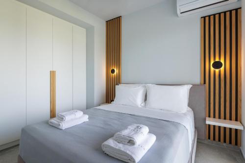 ein Schlafzimmer mit einem Bett mit zwei Handtüchern darauf in der Unterkunft SUMMER PEARLS LUXURY VILLAS in Polychrono