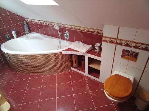 ein Badezimmer mit einer großen Badewanne und einem WC in der Unterkunft Relax in Zlatá Koruna