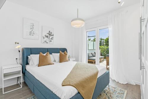 1 dormitorio con 1 cama azul con sábanas y almohadas blancas en Comeback Aguacate golf playa sol, en Motril
