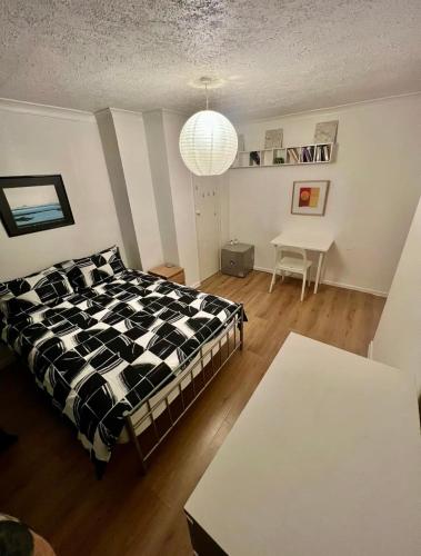 a bedroom with a bed and a table at Whitechapel Rooms R2 in London