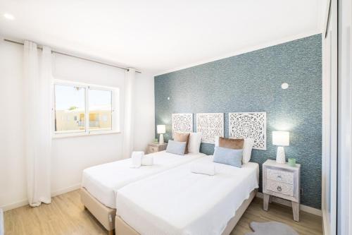 ein weißes Schlafzimmer mit zwei Betten und einem Fenster in der Unterkunft Benjamin Apartment in Guia