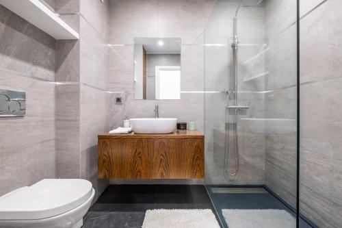 a bathroom with a toilet and a sink and a shower at Benjamin Apartment in Guia