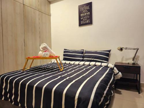 ein Schlafzimmer mit einem Bett und einem Tisch darauf in der Unterkunft 1 Dream Home @ Utropolis Studio 4星级简单舒适享受漂亮夜景和泳池 in Shah Alam