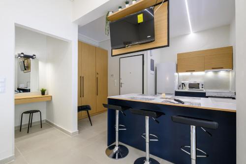 une cuisine avec un comptoir bleu et des tabourets dans l'établissement Siesta Apartment, à Kalamata