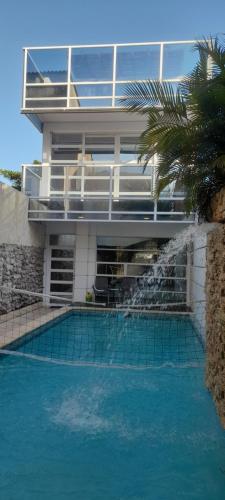 Casa con Piscina Privada Playas del Mar في كارتاهينا دي اندياس: منزل به مسبح امام مبنى