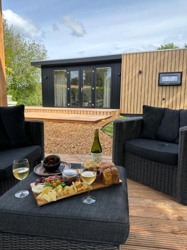 a table with a tray of food and two glasses of wine at Chalet de Blauwe regen in Balkbrug