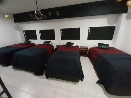 a room with three beds and three monitors on the wall at departamento amplio el molino in Tehuacán