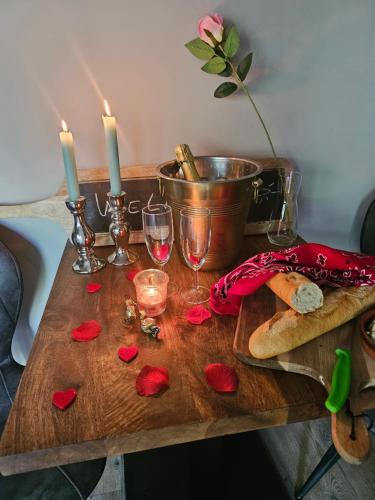 una mesa con dos velas y copas de vino. en Jacuzzi huisje De Berenshoeve, en Emmen