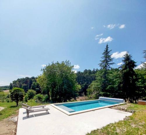 - une piscine avec un banc et une table de pique-nique dans l'établissement Les Jardins de la Beylie - Gîte, à Preyssac-dʼAgonac