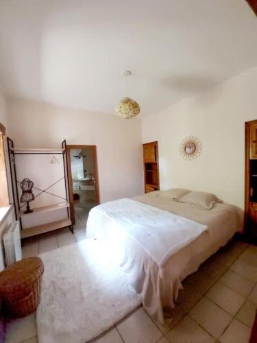 une chambre avec un grand lit blanc dans une pièce dans l'établissement Les Jardins de la Beylie - Gîte, à Preyssac-dʼAgonac