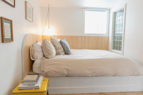 a bed with white sheets and pillows in a bedroom at Le Central par Maison Dudley in Lac-Mégantic