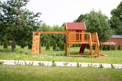 un parque infantil de madera en un campo de césped en STOLEMOWE Wzgórze Domek Leśnika, en Perlino