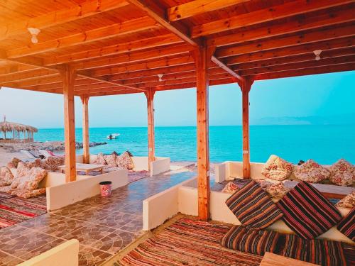 a pavilion at the beach with the ocean in the background at Star Dune Camp in Nuweiba