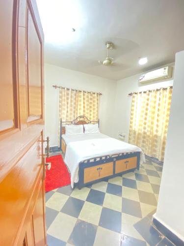 a bedroom with a bed and a checkered floor at Private 2bhk villa with kitchen Candolim-calangute Goa CW01 in Candolim