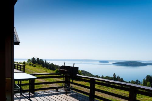a deck with a grill and a view of a lake at Cabañas Mirador Lago Ranco in Lago Ranco