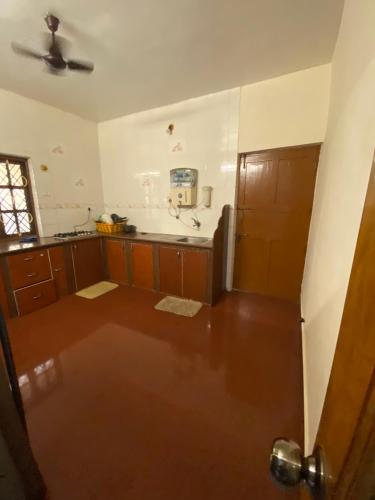 a kitchen with wooden cabinets and a ceiling fan at Private 2bhk villa with kitchen Candolim-calangute Goa CW01 in Candolim