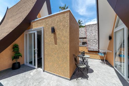 a building with a patio with a table and chairs at Siam Royal View Villas in Ko Chang