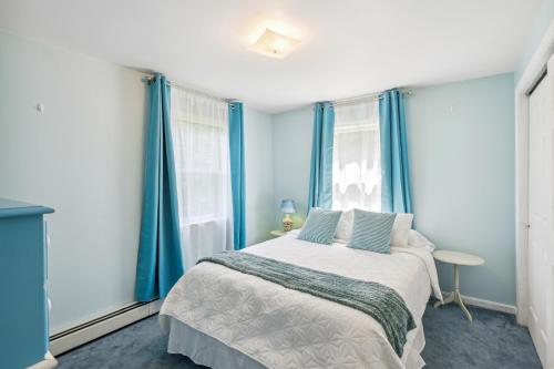 a bedroom with blue curtains and a large bed at Charming and Scenic Gouldsboro Getaway with Patio! in Gouldsboro