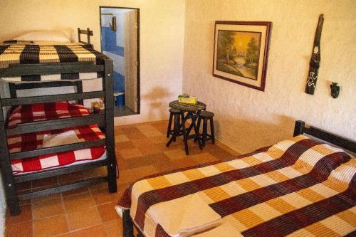 a bedroom with two bunk beds and a table at HOTEL CAMPESTRE ABRAZO DEL ANGEL in Aratoca