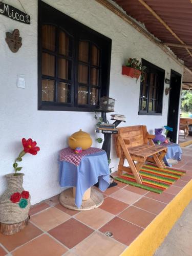 a patio of a house with a table and a bench at HOTEL CAMPESTRE ABRAZO DEL ANGEL in Aratoca