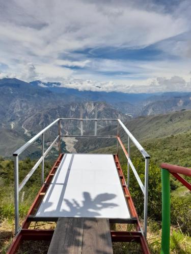 a bed on top of a mountain with a view at HOTEL CAMPESTRE ABRAZO DEL ANGEL in Aratoca