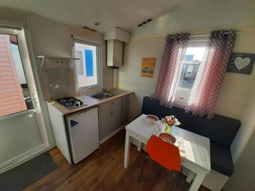 una pequeña cocina con una mesa pequeña y una pequeña cocina con fregadero en VILLA MARINA 4, en Los Barrios