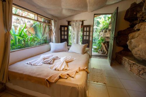 1 dormitorio con 1 cama con toallas en Pousada Flor de Açucena, en Igatú