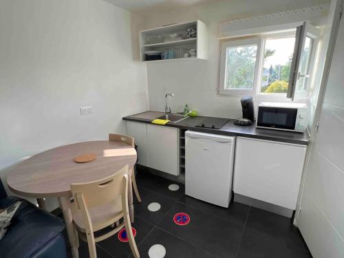 a small kitchen with a table and a microwave at Studio(1) cosy, 2 pers aéroport Marseille in Marignane