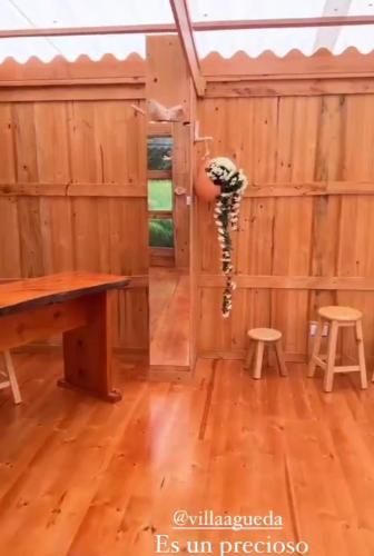 a room with a wooden wall with a table and stools at Casa Mujer Villa Agueda in Chocontá