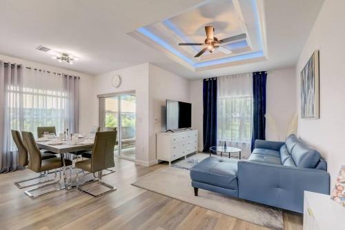 a living room with a table and a blue couch at Modern Vacation House in Rotunda-West