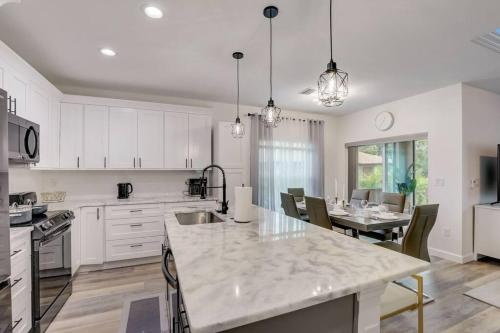 a kitchen with white cabinets and a table with chairs at Modern Vacation House in Rotunda-West