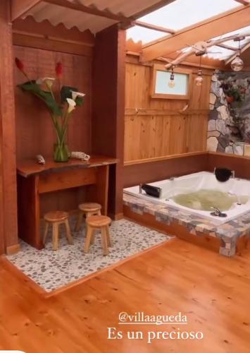 a bathroom with a tub and some stools in it at Casa Mujer Villa Agueda in Chocontá