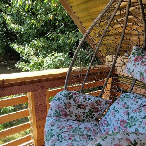 a porch swing with pillows on a porch at Provence Suceava in Suceava